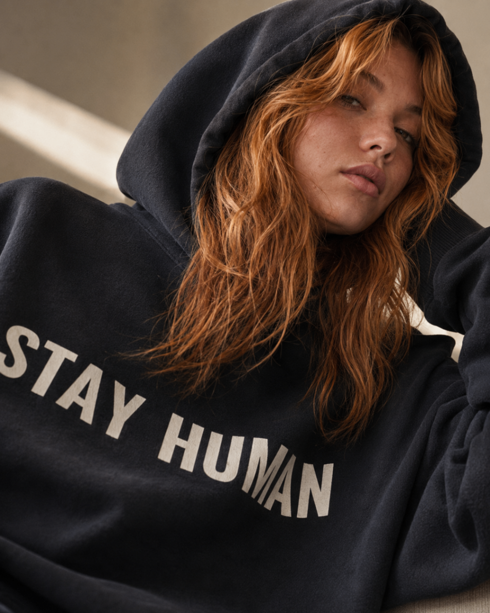 Close portrait of the APXO Stay Human Heavyweight Hoodie with the hood up, showing the cream print and heavyweight fleece texture.
