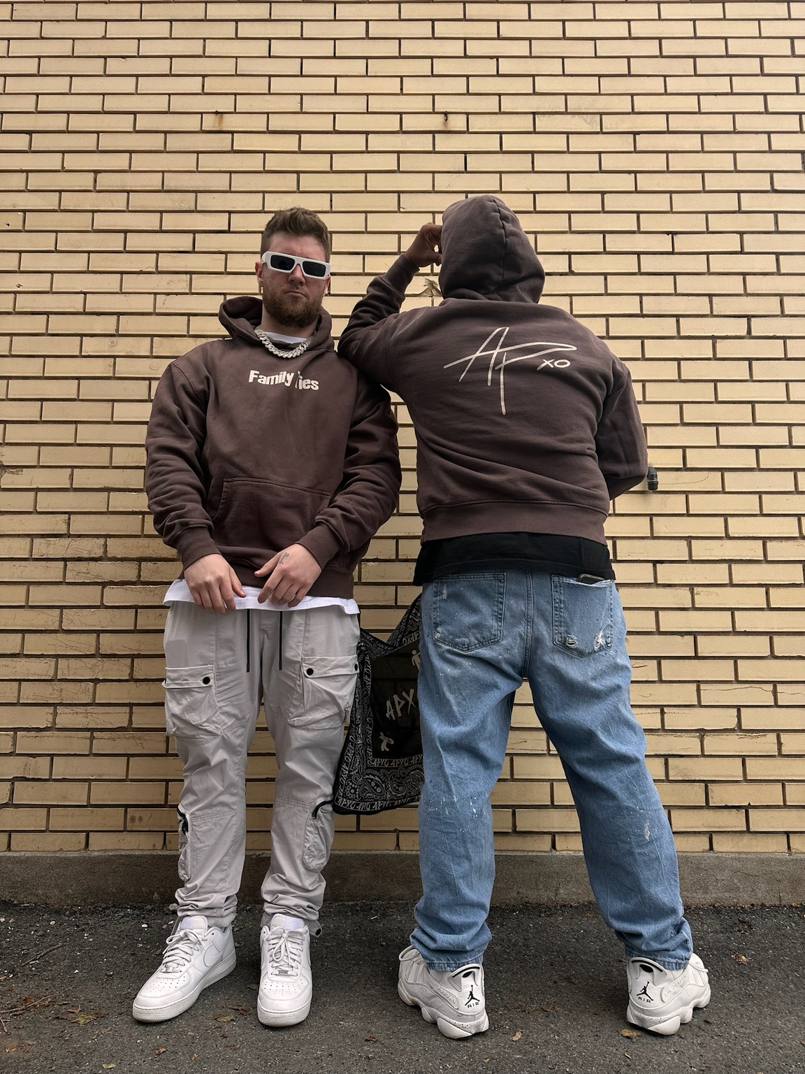 Two figures against a brick wall wearing pieces from the Family Ties collection
