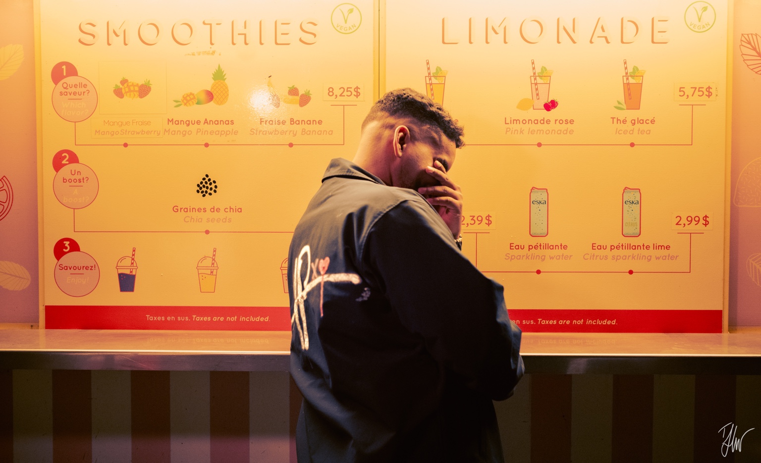 APXO in a custom APXO jacket in front of a warm-lit smoothie counter