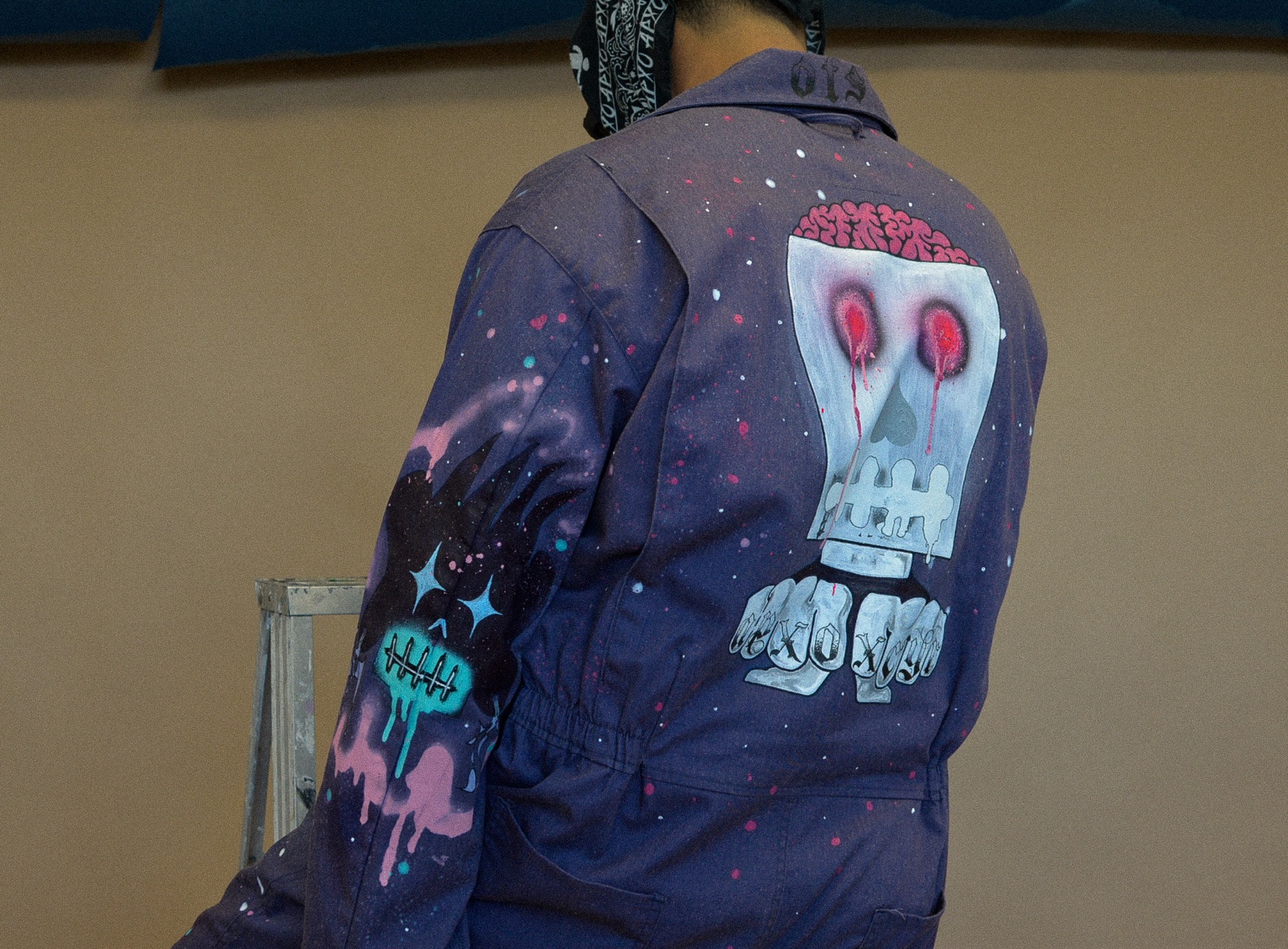 Close-up of the hand-painted skull artwork on the back of the XCYR boiler suit