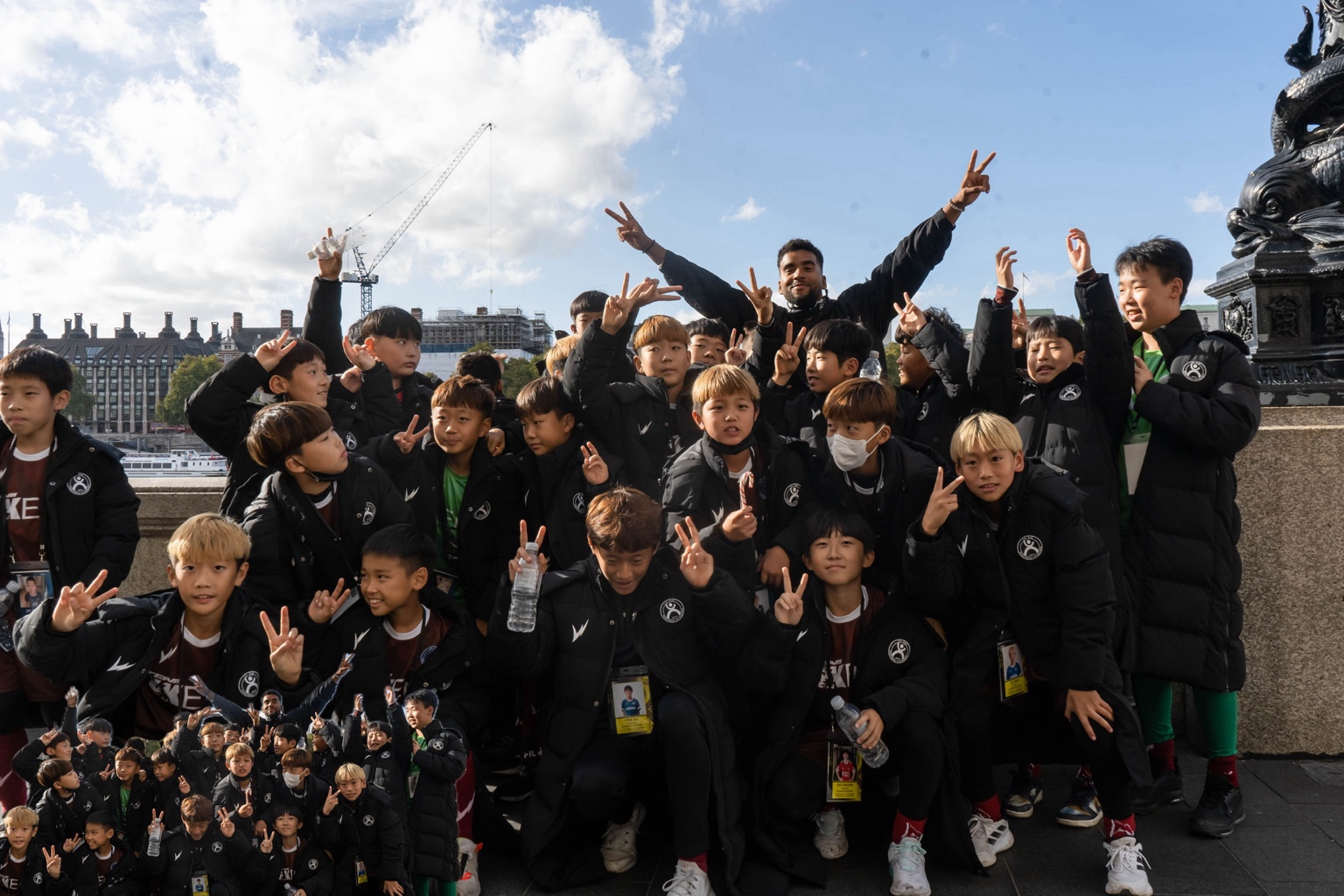 APXO outdoors with a youth football team in matching jackets during the We The Ones shoot